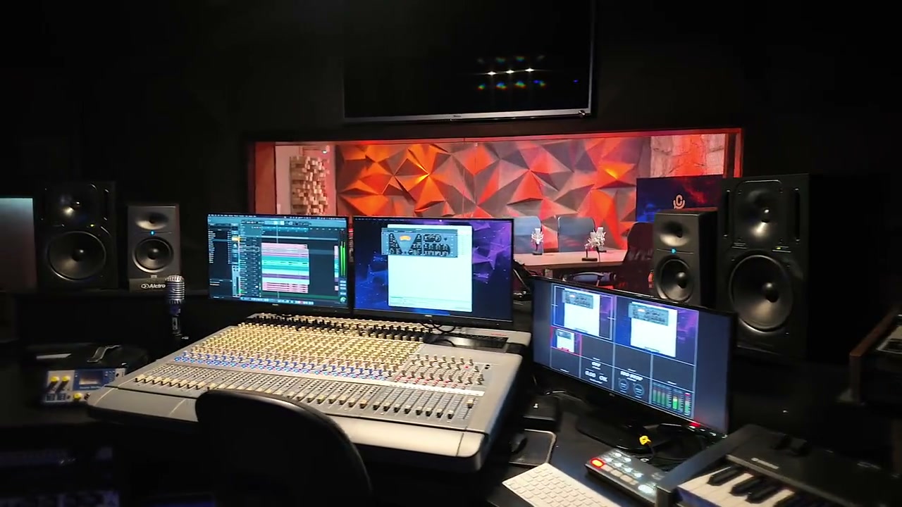 Sala de controle com mesa de áudio e monitores de estúdio